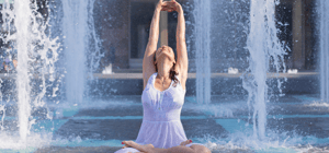 Woman doing yoga in a waterfall