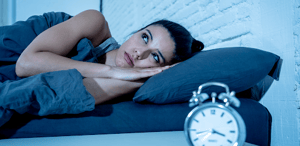 Woman lying awake looking at clock