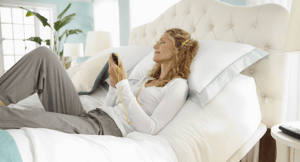 Woman listening to music on adjustable bed
